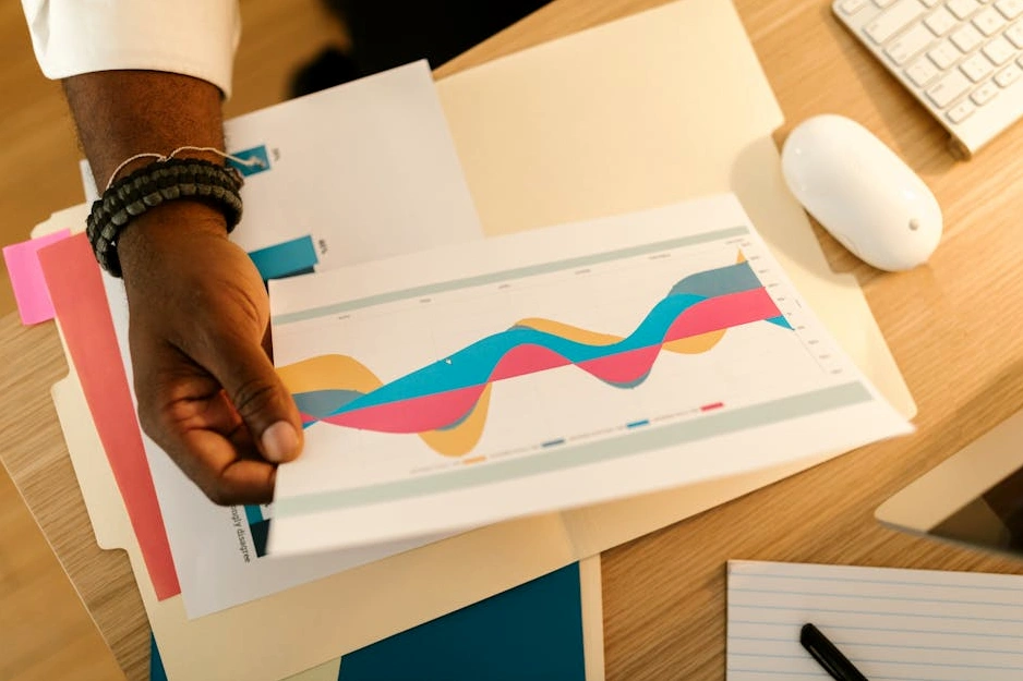 Masanın üzerinde duran finansal belgeler ve bir kalem